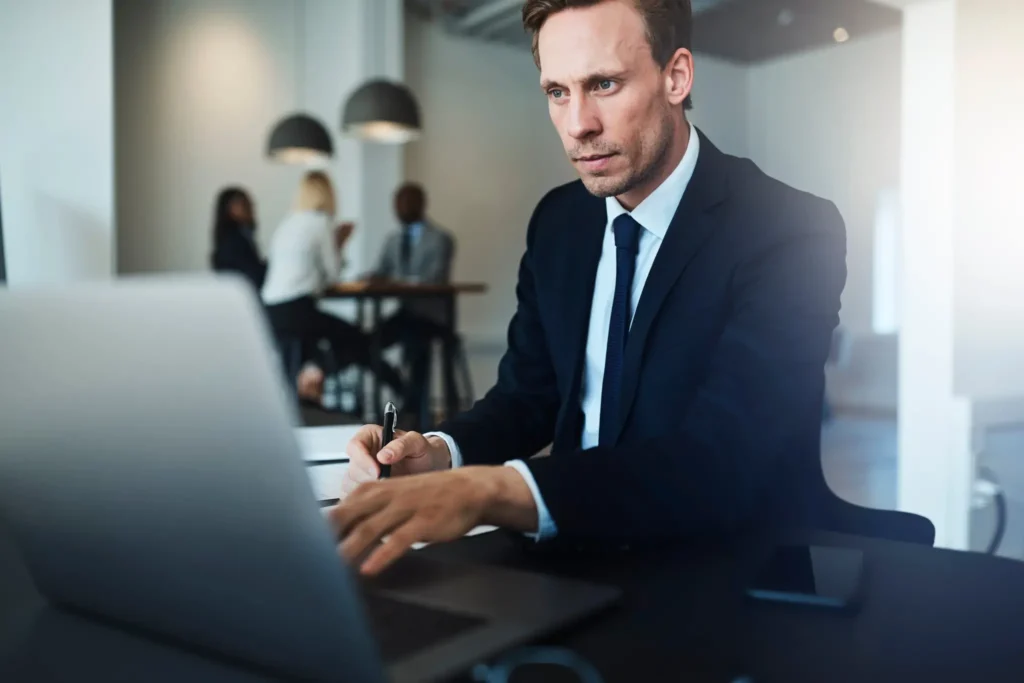 a man in a suit and tie working on a laptop