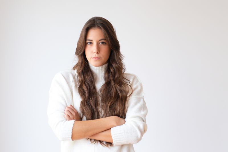 younger woman standing with her arms crossed