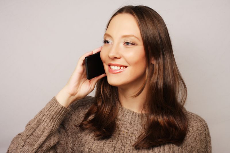 a young woman smiling during a phone call