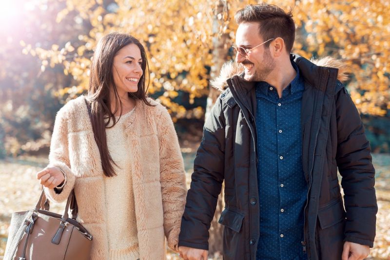 Young couple holding hands and walking outside